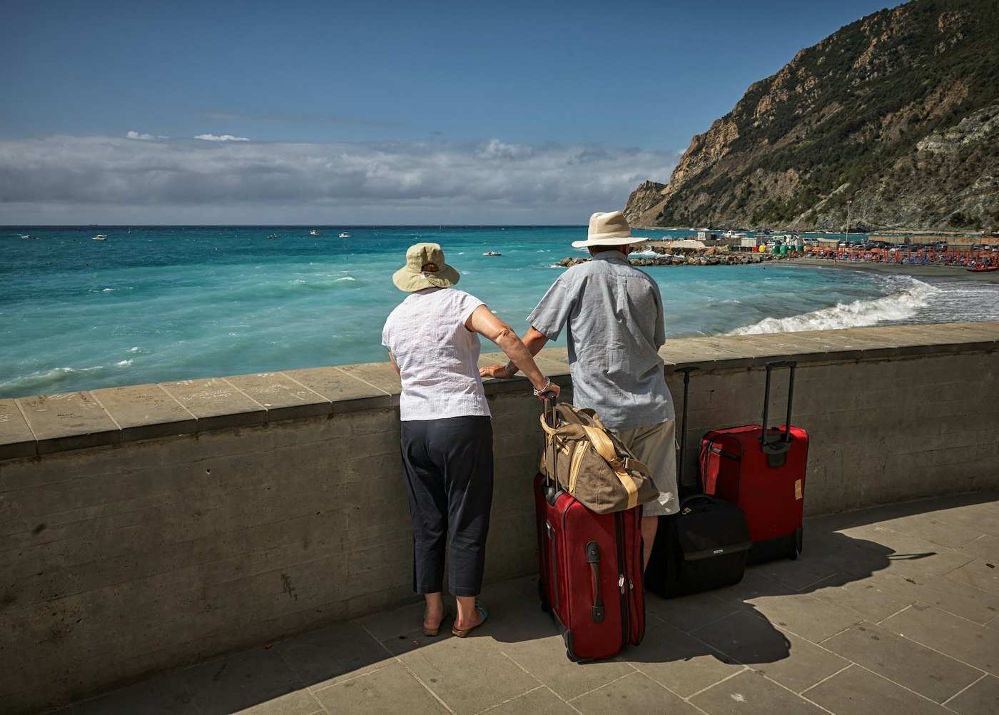 Couple standing beside a seawall looking out at the beach during a romantic weekend getaway
