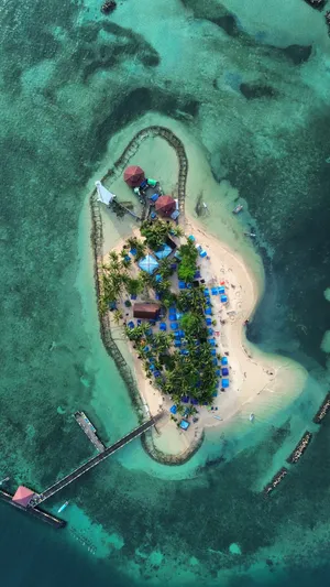 Aerial view of a tropical island resort surrounded by turquoise waters in Belize
