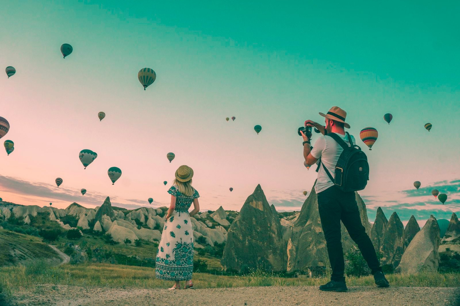 Couple enjoying a romantic weekend getaway together watching hot air balloons at sunrise