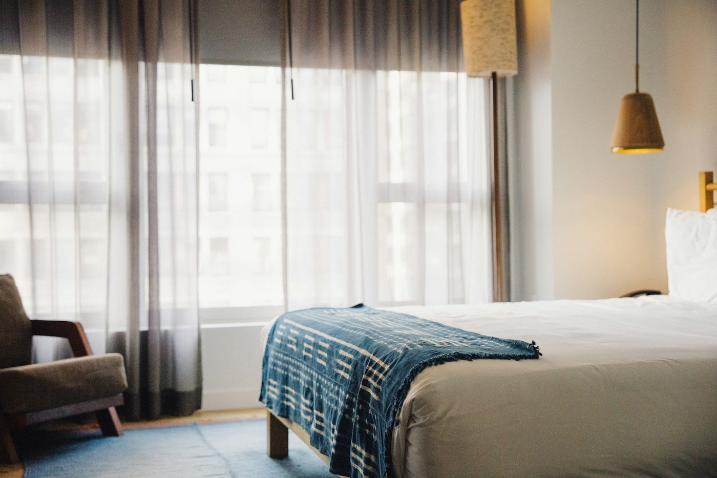 Cozy boutique hotel room with a bed and chair, representing Savannah's historic boutique luxury inns