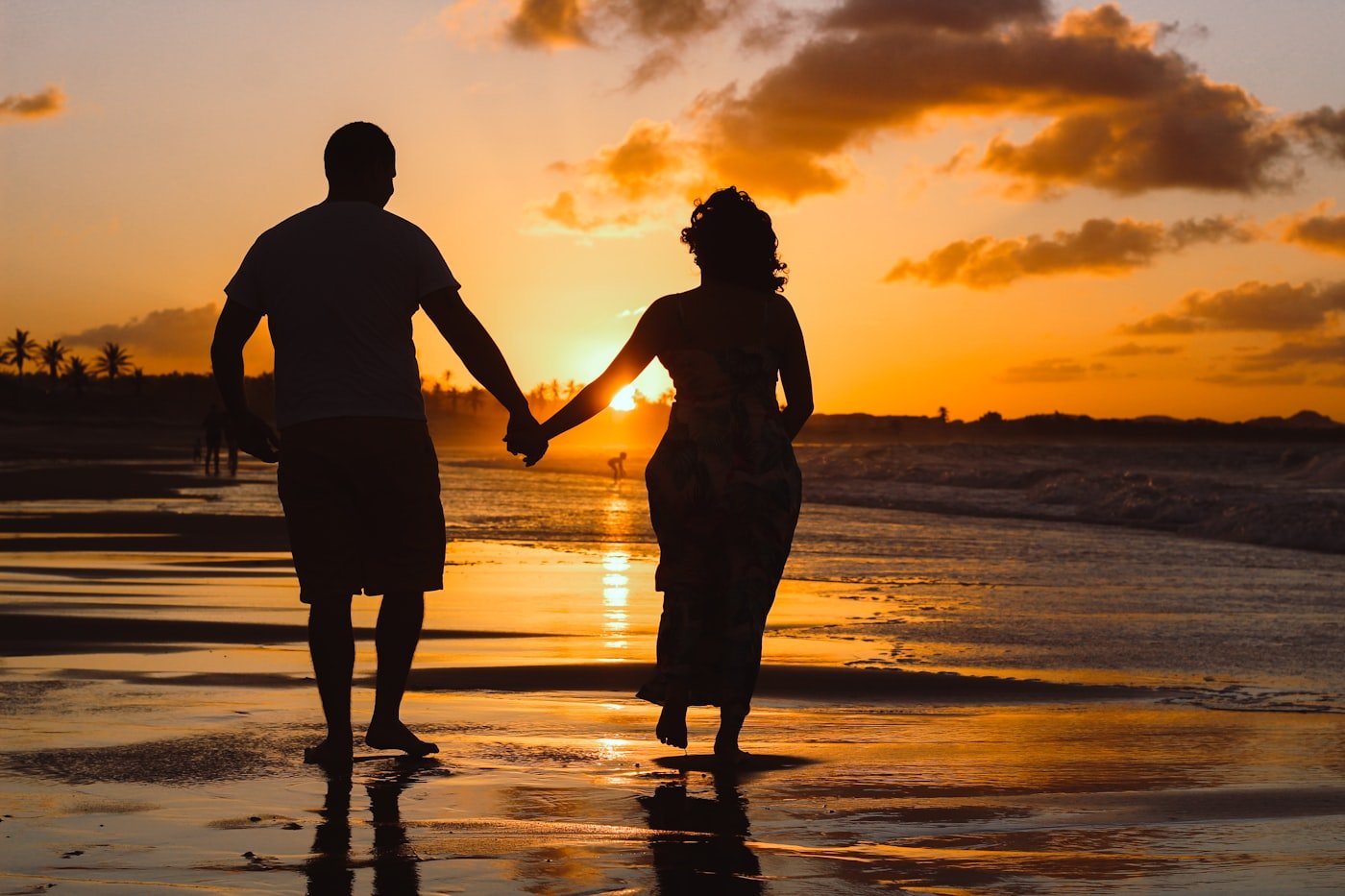 Couple standing on shallow water at golden hour during a luxury honeymoon destination