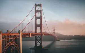 Golden Gate Bridge shrouded in fog during sunset in San Francisco